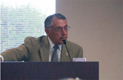 Man speaking from a podium at the first GQCHCC meeting